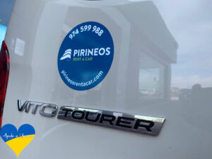 Imagen de la furgoneta de Pirineos Rent a Car solidaria de 9 plazas y el logo del rent a car